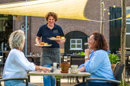 Stel geniet van een lunch op het terras van Landgoed Hackfort, midden in het groen van Vorden in de Achterhoek